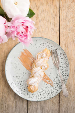 Eclair with buttercream filling and powdered sugar