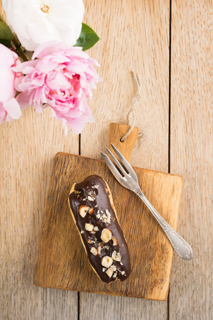 Eclair with chocolate ganache and nuts topping