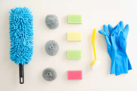 Collection of pastel-coloured cleaning supplies on white backgroundの写真素材