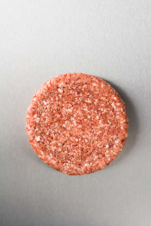 Burger patty from ground beef on stainless steelの写真素材