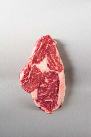 Raw rib eye steak on stainless steel