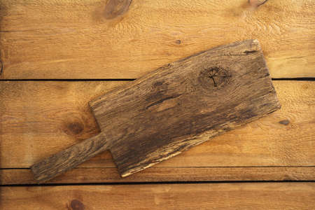Old wooden cutting board on wooden background