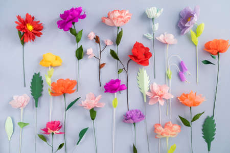 Colourful handmade paper flowers on light blue backgroundの写真素材