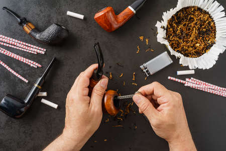 Man cleaning his pipes with a pipe cleanerの写真素材