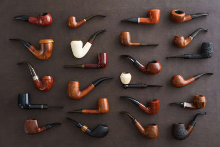 Collection of pipes on brown faux leatherの写真素材