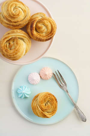 Fresh baked cruffins trend pastry with meringues on pastel tablewareの写真素材