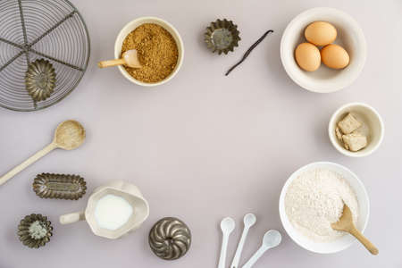 Flatlay collection of tools and ingredients for home baking on light grey background with copyspace...