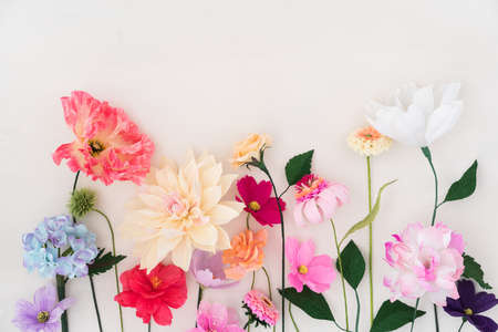 Crepe paper flowers on white wooden backgroundの写真素材
