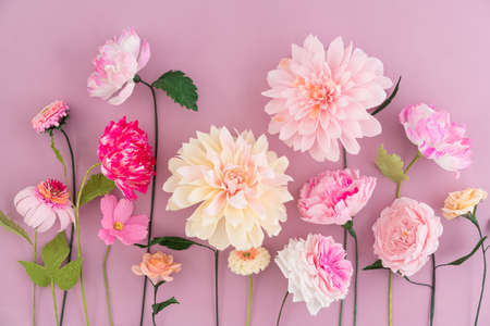 Crepe paper flowers on pink wooden backgroundの写真素材