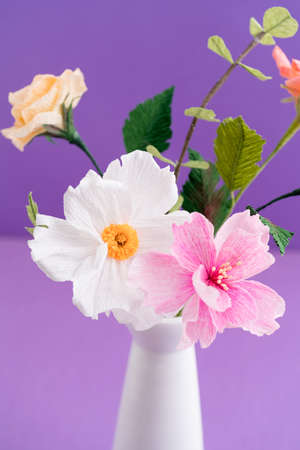 Crepe paper flower bouquet with cosmos, roses and eucalyptus in a vase on purpleの写真素材