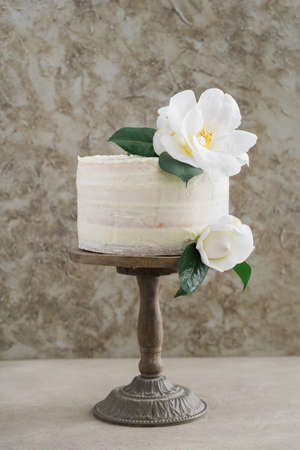 Naked buttercream layer wedding cake decorated with camelliasの写真素材
