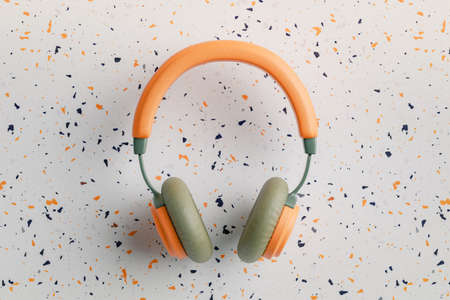 Orange and green vintage headphones on terrazzo background, 3D renderingの写真素材