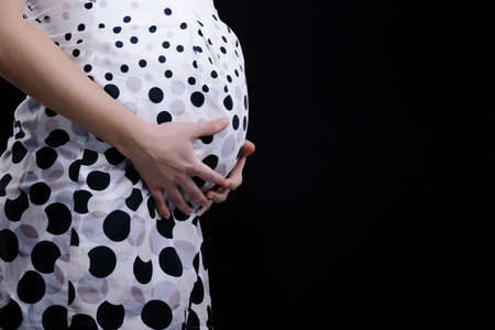 pregnant mother tummy on black backgroundの写真素材