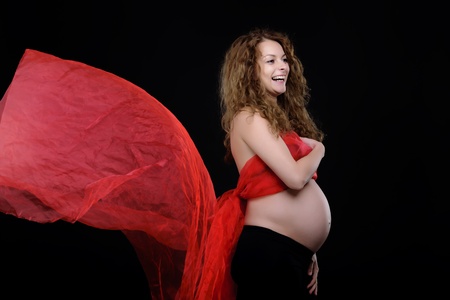beautiful curly young woman expecting a a baby; pregnancy