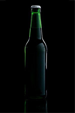 a green bottle beer over black background with shadowの写真素材
