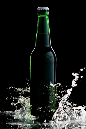 Beer in green bottle with water splash isolated on blackの写真素材