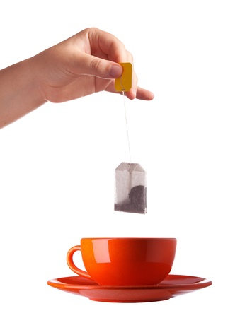 Woman hand with teabag and red cup isolated on white backgroundの写真素材