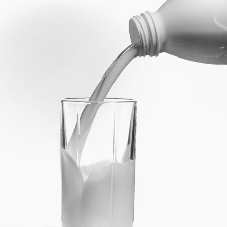 being poured from a bottle in a glass milkの写真素材