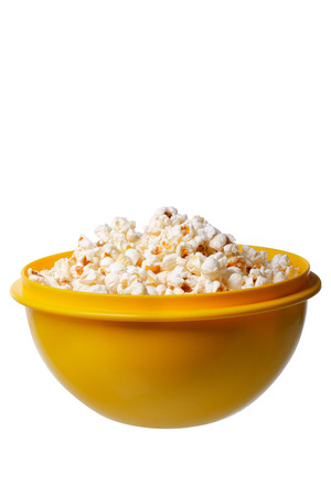 popcorn in a yellow bowl on white backgroundの写真素材