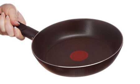 frying pan in hand, isolated on white backgroundの写真素材