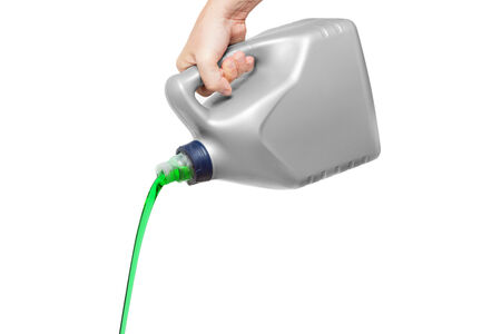 Green engine oil pouring from a canister in hand isolated on white backgroundの写真素材