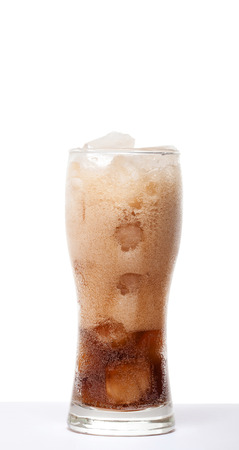 the liquid is poured into a glass with ice isolated on a white backgroundの写真素材