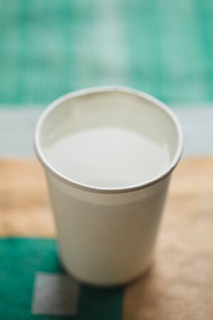Paper cup a white color, on table on bright backgroundの写真素材