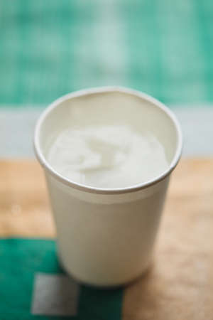 Paper cup a white color, on table on bright backgroundの写真素材