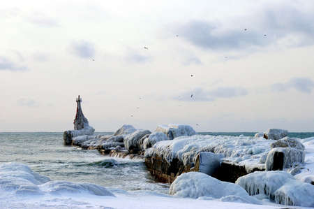 The Icy pier.The Sea pier cover ice. The Winter evening seaborne. The Frost and wind.の写真素材