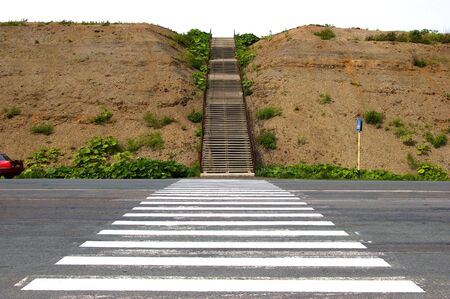 The Pedestrian crossing leads to high stairway on mountain.