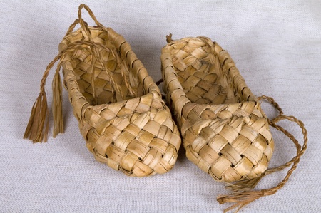 Pair  bast shoes birch bark on a linen fabric    