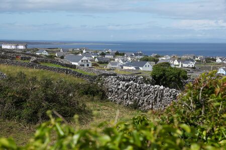 stone fence and houses on inisheer island on aran islands in Irelandの写真素材