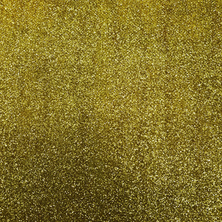 Golden Glitter background. Brilliant dust abstract surface. Shimmer hologram crystal texture. Holiday sparkle backdrop.の写真素材