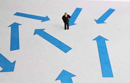 Figures of businessmen in front of blue arrows symbol for direction search and business ideasの写真素材