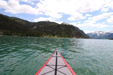 Top of a kayak in a lake with turquoise water and mountains in the backgroundの写真素材