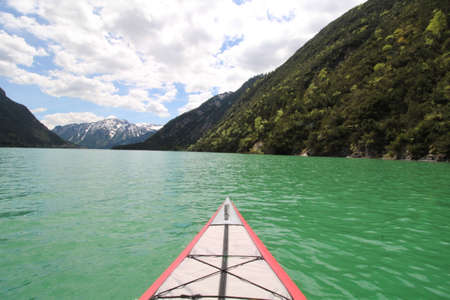 Top of a kayak in a lake with turquoise water and mountains in the backgroundの写真素材
