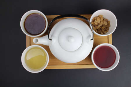 Japanese teapot with small cups and different types of teaの写真素材