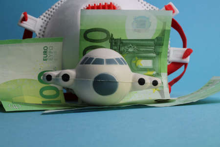 small plane with face mask and money stands for cancellation costsの写真素材