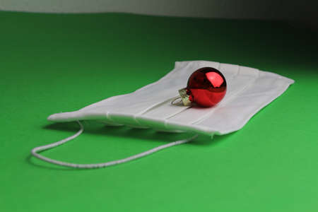 small Christmas ornament on a face mask with a green background