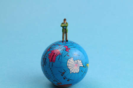 small figure stands on a small globeの写真素材