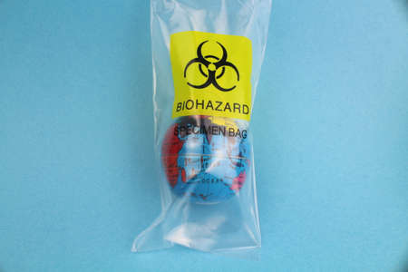 small globe in a plastic bag with the biohazard symbol