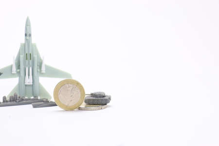 small model of a fighter plane with euro coins in the foreground represents the arms industry