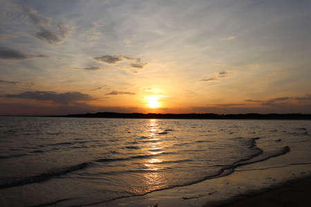 Sunset on the beach with the sea in the foregroundの写真素材