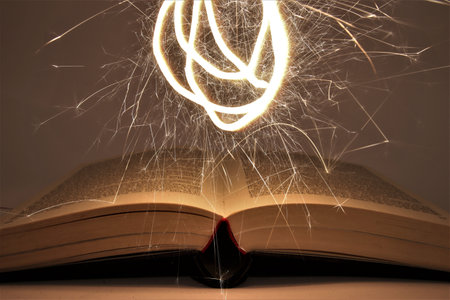Open book with burning magic ball on dark background, close-upの写真素材