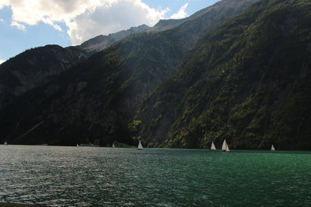 the sun is shining on a part of a lakesideの写真素材