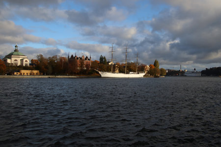 beautiful white sailboat in front of historical buildingsの写真素材