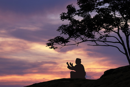 Silhouettes Muslim prayer,the light of faith, hope, faith, supplication,Muslim boy praying faith in Allah God of Islam supremelyの写真素材