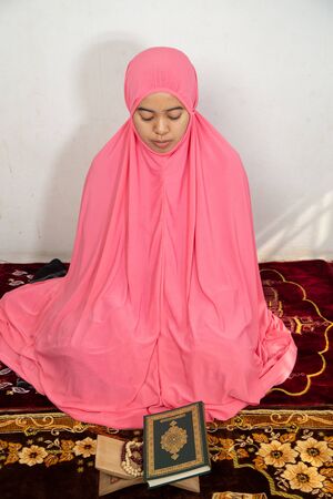Muslim women sitting and reading Quran for prayerの写真素材