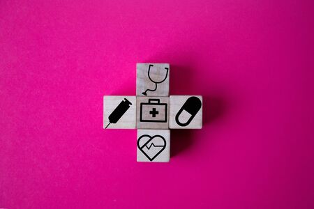 wood cube with a medical symbol  angle Flat lay,Concept: Health insurance family covid-2019 epidemic,management protect healthcare to a virus,care service doctor treatment for hospitalの写真素材