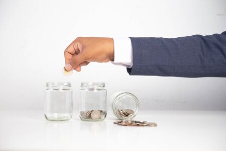 business man hand holding a coin in a glass bottle,Concept: saving  coin family money for home dreams,
symbol growing  investment success wealth to  benefit,business growth  banking for  cashの写真素材